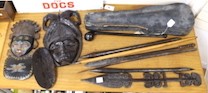 A selection of clubs and weapons to include a knobkerry, together with tribal masks